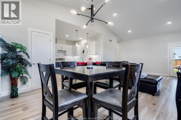 Dining area interior with a large dark wood table, chairs, and a horizontal window. - 304 Horizon Lane, Chatham