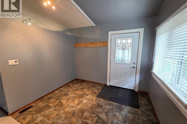 Another angle of the living room showing seating and bookshelves - 304 Second Avenue E, Lampman