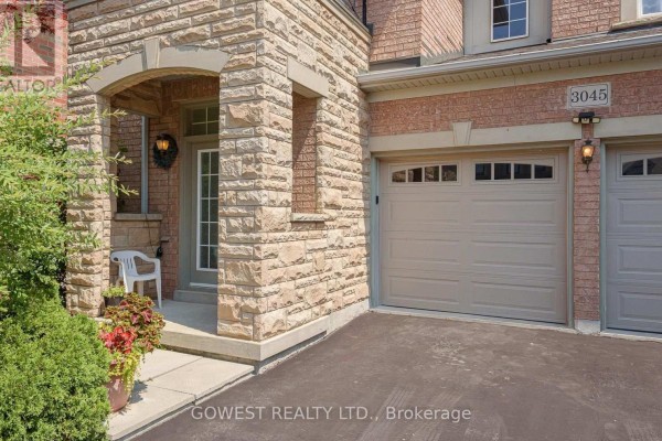Covered entryway with stone accents and garage door. - 3045 Ferguson Drive, Burlington