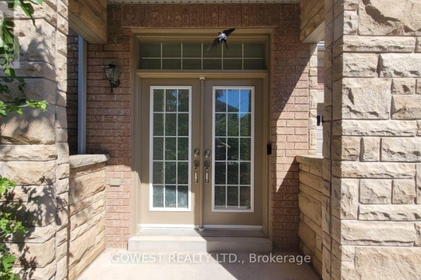 Close-up of double front doors with glass panes and stone facade. - 3045 Ferguson Drive, Burlington