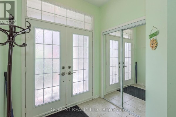 Interior entryway with tiled floor, double doors, and mirrored closet. - 3045 Ferguson Drive, Burlington
