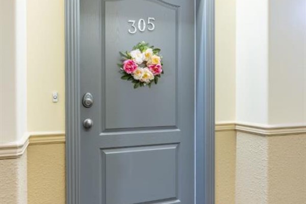 Apartment door number 305 with floral wreath and doorbell. - 305, 29 River Ridge Drive Nw, Medicine Hat