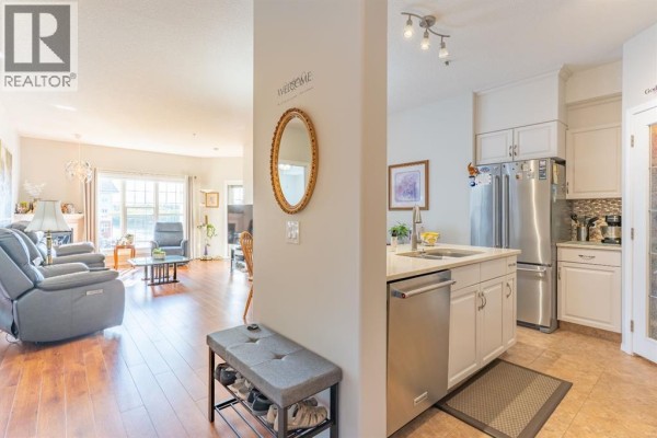 Open concept living room and kitchen with fireplace and stainless steel appliances. - 305, 29 River Ridge Drive Nw, Medicine Hat