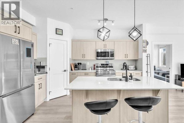 Bathroom featuring a vanity, toilet, and shower with a dark curtain. - 305, 30 Sage Hill Walk Nw, Calgary
