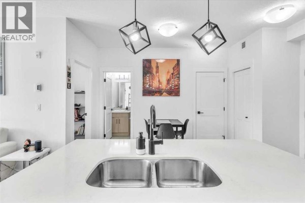 Living room with a sofa, TV unit, and large window for natural light. - 305, 30 Sage Hill Walk Nw, Calgary