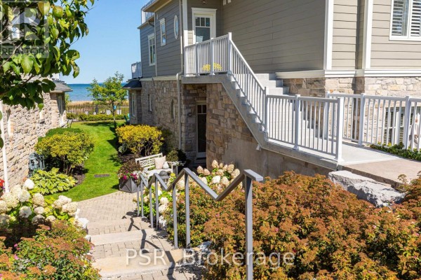 Pathway leading up to townhouse entrance with stone and siding exterior. - 305 - 40 Trott Boulevard, Collingwood