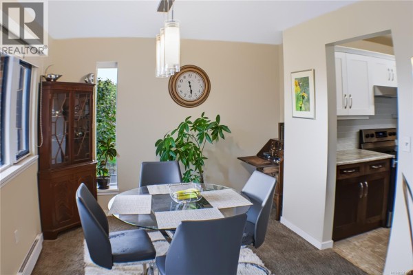 Landscaped garden with green grass and mature trees overlooking a body of water. - 305 103 Gorge Rd E, Victoria