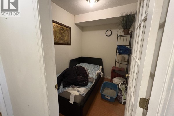 Small bedroom with a bed, shelving unit, and clock - 305 1035 Auckland Street, New Westminster