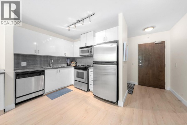 Kitchen area with stainless steel refrigerator and view of entrance hallway. - 305 175 W 1st Street, North Vancouver