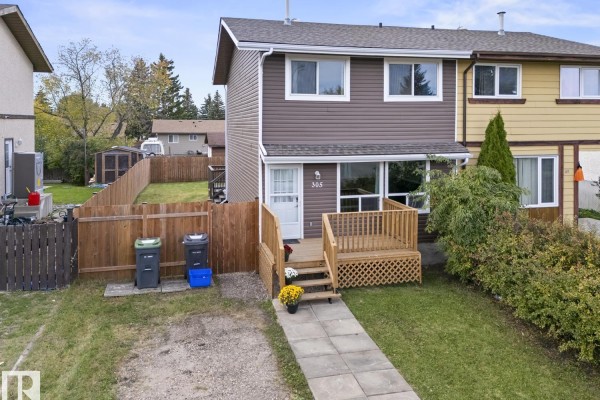 Side exterior view of the duplex with a fenced yard and gravel driveway. - 305 19 St, Cold Lake