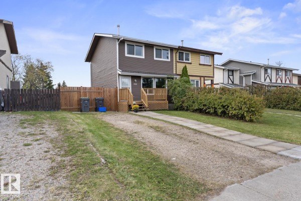 Gravel driveway leading to the front of the duplex with a concrete walkway. - 305 19 St, Cold Lake