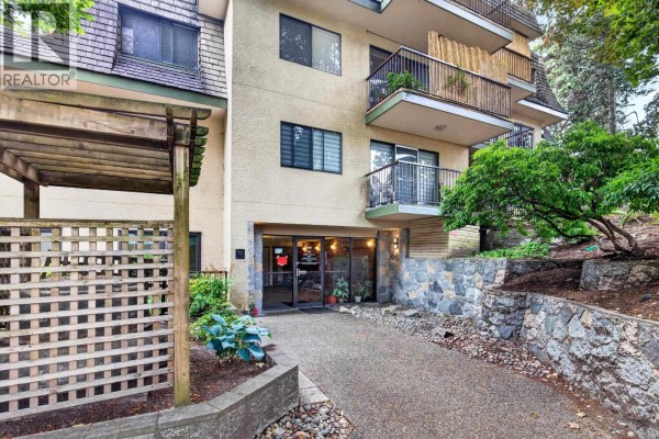 Empty kitchen with beige cabinets, tile flooring, and light fixture - 305 466 E Eighth Avenue, New Westminster