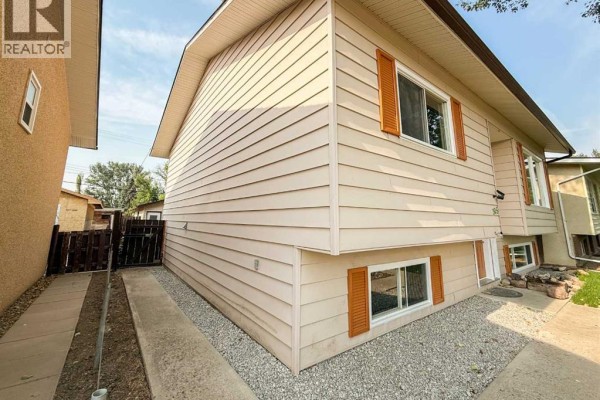 Aerial view of the backyard of 305 51 Ave, showing a wooden deck and garage. - 305 51 Avenue, Coalhurst