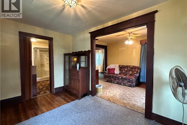 Living room with floral sofa and display cabinet - 305 North Cayuga Street W Dunnville