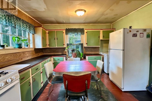 Retro kitchen with green cabinets, diner table, and chairs - 305 North Cayuga Street W Haldimand