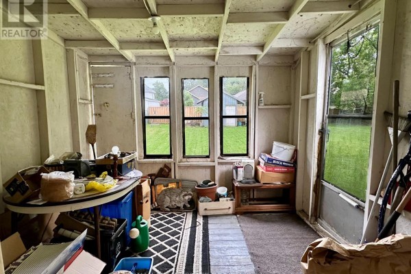 Cluttered room with table, rug, watering can, boxes, and windows overlooking backyard - 305 North Cayuga Street W Haldimand