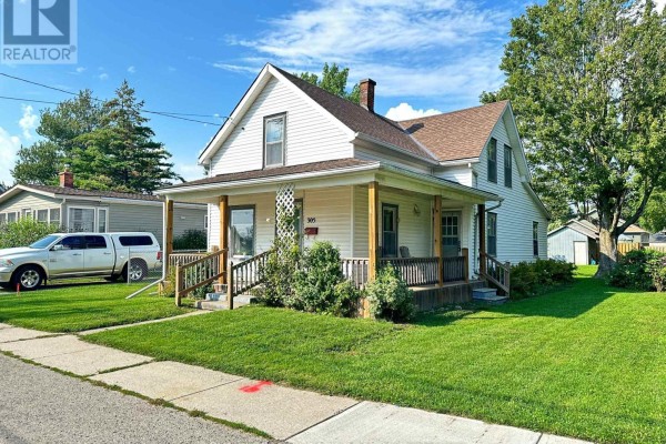 Right side view of a white house with a covered porch and green lawn. - 305 North Cayuga Street W, Haldimand