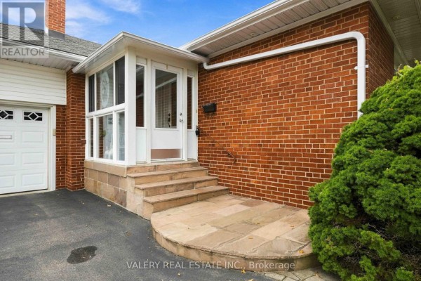 Close-up of the front porch entrance with stone steps and brick exterior walls. - 305 Renforth Road, Toronto