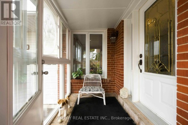 Interior view of a sunroom with a white chair and screened doors. - 305 Renforth Road, Toronto