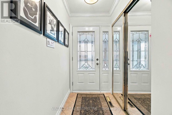 Interior hallway with white walls, beige tiled floor, double glass doors, and mirrored closet. - 305 Renforth Road, Toronto
