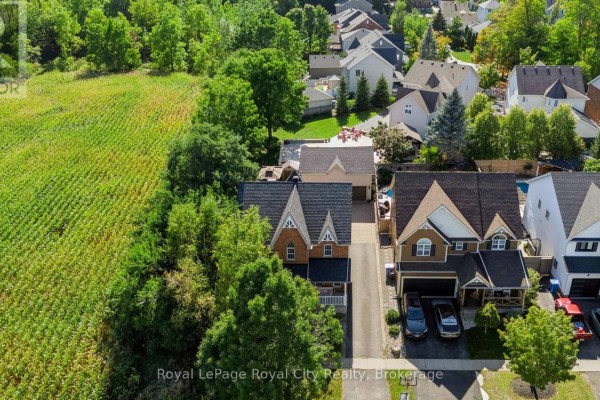 Aerial view of houses on a street, with a cornfield and trees to the left. - 305 Ridge Road, Guelph/eramosa