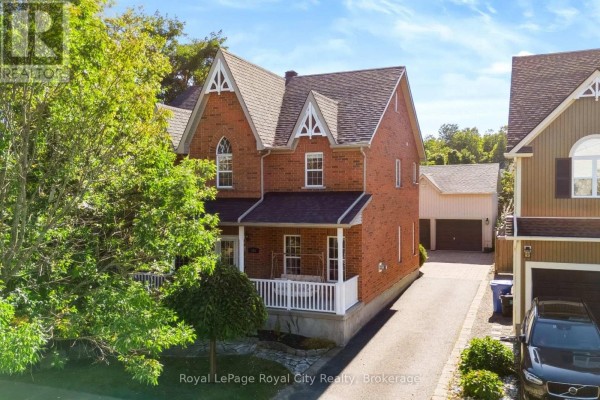 Side and front view of a brick house with a driveway and neighbouring properties. - 305 Ridge Road, Guelph/eramosa