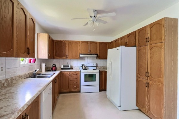 Dining room with a wooden table, six chairs, a china cabinet, and a sliding glass door. - 305 Rue Des Forages, Gatineau