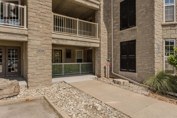 Aerial view of beige apartment buildings with dark roofs and surrounding parking lots. - 306 - 1441 Walker's Line, Burlington