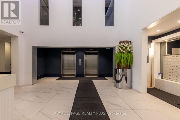 Apartment building entrance with two elevators, contemporary decor, and mailboxes. - 306 - 16 Concord Place, Grimsby