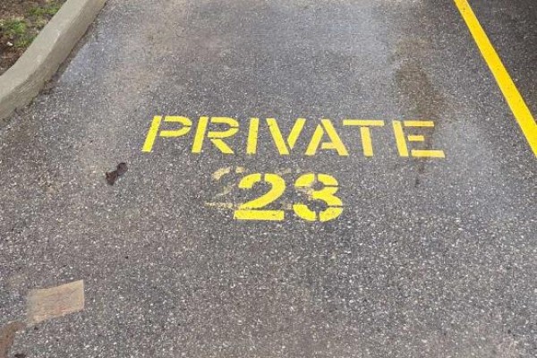 Asphalt ground with yellow line and painted text "PRIVATE 23" in yellow stencil. - 306 - 308 Lester Street, Waterloo