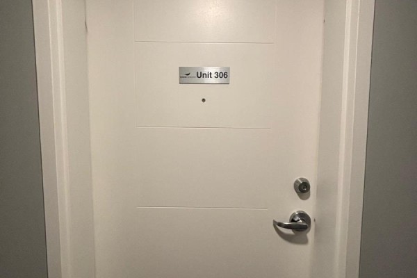 Close-up view of a white apartment door with silver hardware and a "Unit 306" plaque. - 306 - 308 Lester Street, Waterloo
