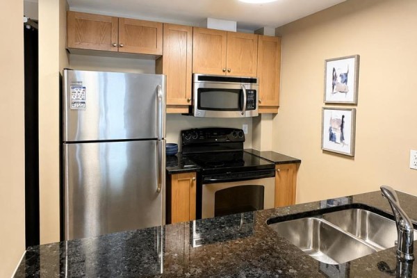 Balcony with a lounge chair, bamboo screen, railing, and view of residential houses. - 306 - 323 Winona Avenue, Ottawa