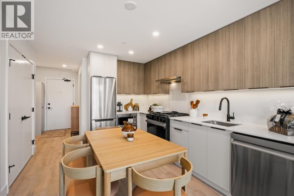 Kitchen and dining area with wood cabinets, white countertops, and stainless steel appliances. - 306 111 Buller Street, Port Moody