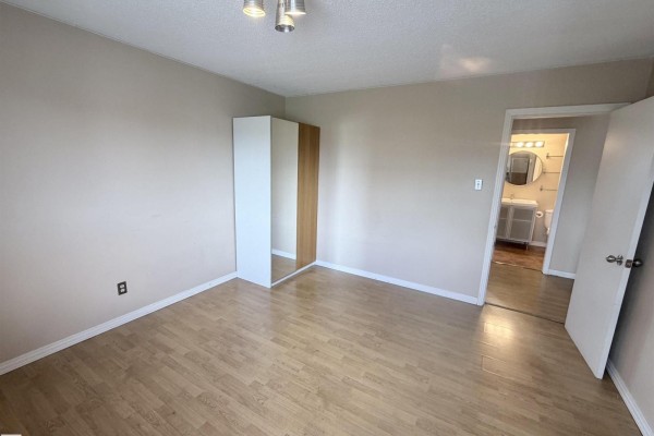 Open living area with hardwood flooring, kitchen access, and natural light from large windows - #306 11340 124 St Nw, Edmonton