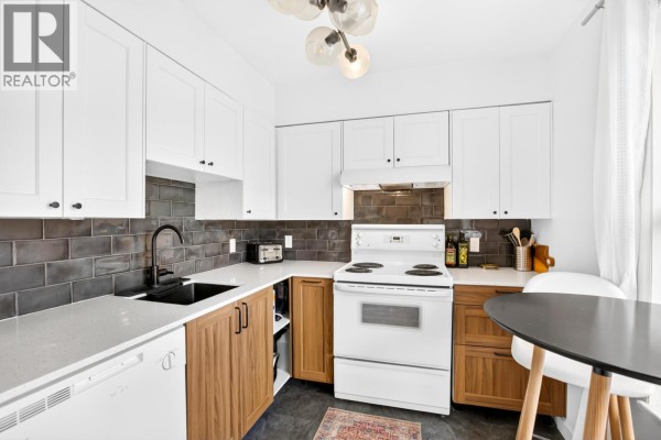 Interior hallway with light wood floors, bi-fold closet doors, and modern chandelier. - 306 22347 Lougheed Highway, Maple Ridge