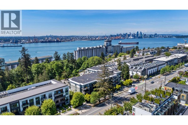 Aerial view of North Vancouver waterfront with apartment buildings and city skyline. - 306 707 E 3rd Street, North Vancouver