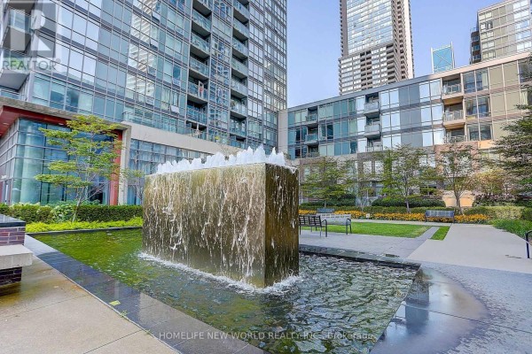 Courtyard with a modern water feature and manicured greenery. - 307 - 15 Fort York Boulevard, Toronto