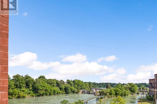 View from apartment window of a wide river with green trees lining the banks. - 307 - 57 Lakeport Road, St  Catharines