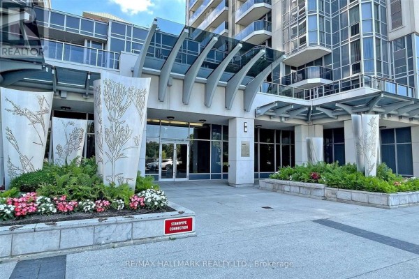 Glass canopy entrance with decorative stone pillars and planters. - 307 - 5791 Yonge Street, Toronto