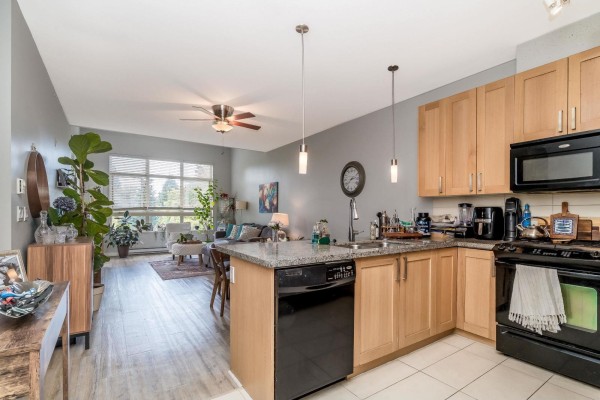 Open concept kitchen and living room with light wood cabinets and granite countertops. - 307 15918 26 Avenue, Surrey