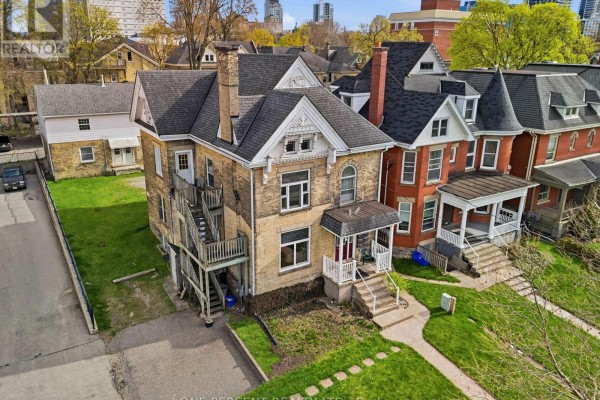 Aerial view of a two-story brick house with an attached wooden staircase on the side. - 307 Central Avenue, London East