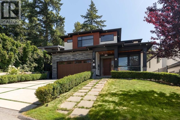 Living room with a fireplace, two sofas, coffee table, and a modern white front door. - 307 Cutler Street, Coquitlam