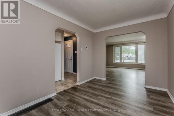 Living room with arched doorways and laminate floors - 307 Dunsmure Road Hamilton