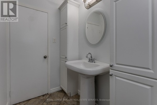 Pedestal sink and oval mirror in bathroom - 307 Dunsmure Road Hamilton