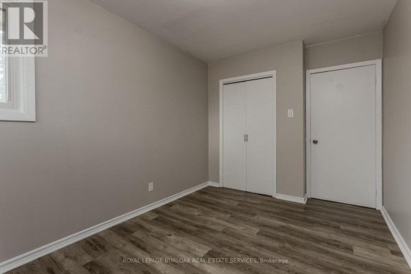 Bedroom with wood-look flooring and closets - 307 Dunsmure Road Hamilton