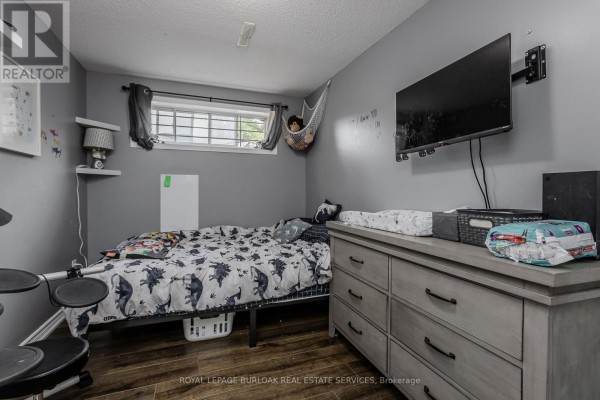 Bedroom with dinosaur bedding, dresser, wall-mounted TV, hammock, and drum set - 307 Dunsmure Road Hamilton