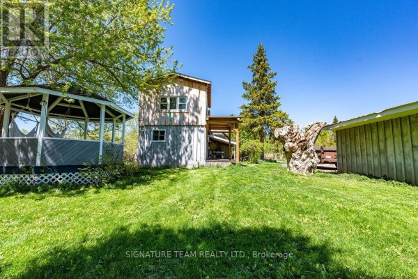 Exterior view of the house with a wooden porch and snow-covered landscape. - 307 Grist Mill Road, North Algona Wilberforce