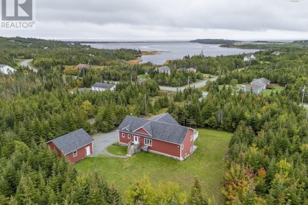 Aerial view of a red house and detached garage on a large, wooded property. - 307 Leslie Road, East Lawrencetown