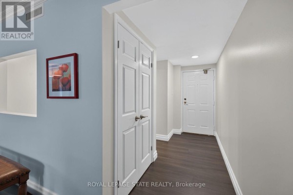 Hallway interior with light blue and grey walls, double white doors, and a view of another white door. - 308 - 150 Wilson Street W, Hamilton