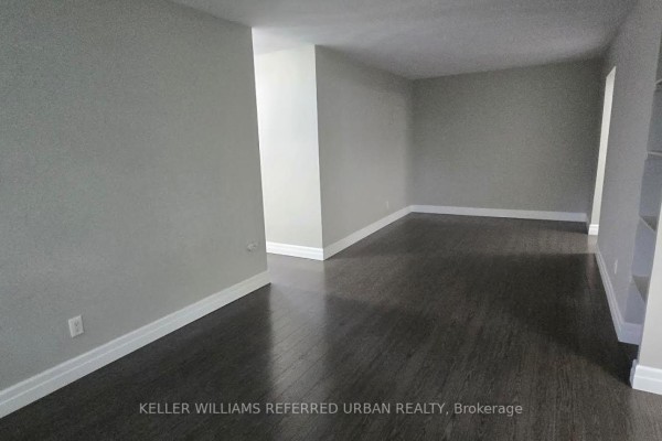 Apartment living and dining area with dark hardwood floors and light grey walls. - 308 - 1901 Bayview Avenue, Toronto